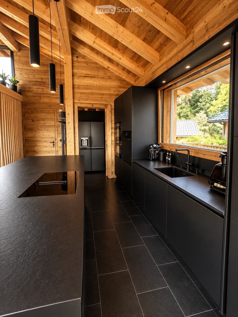 Modern kitchen with dark countertops, black tiled floor, sleek black cabinets, stainless steel appliances, and pendant lights.