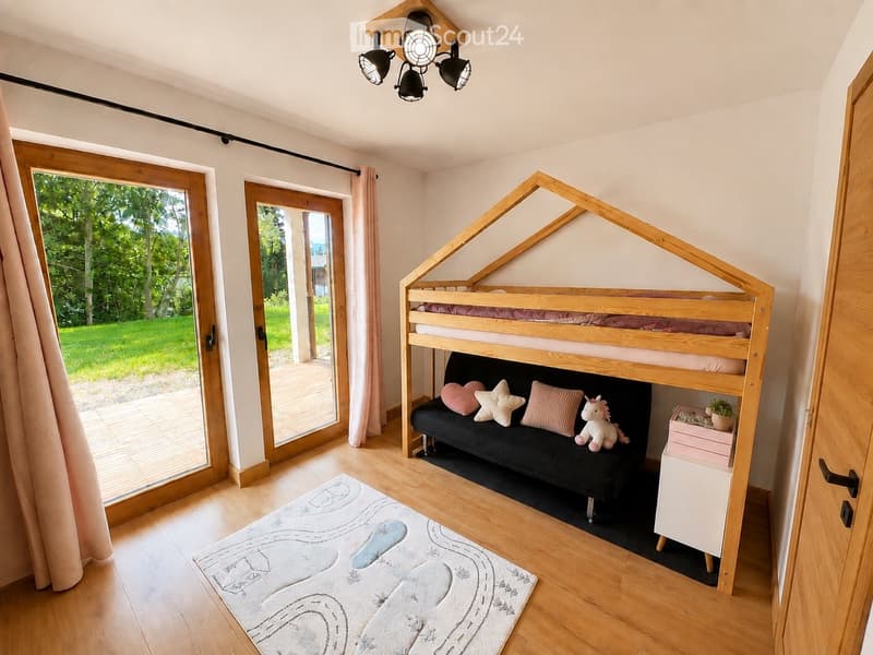 Bright bedroom with wooden bunk bed, sofa beneath, pillows, toy unicorn, storage unit, and a rug with a car design.