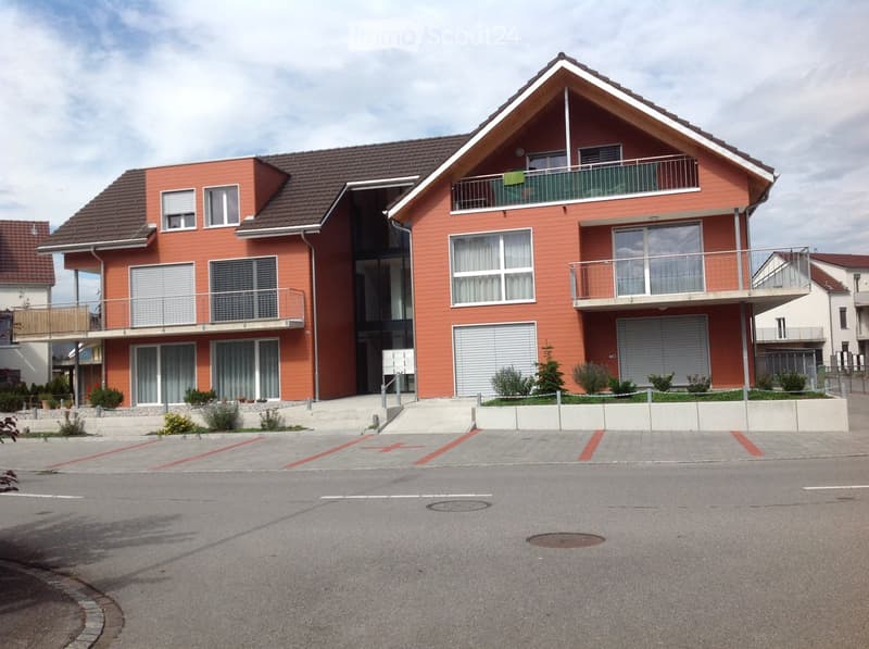 2-story house, red facade, brown roof, balconies on second floor, 2 garages