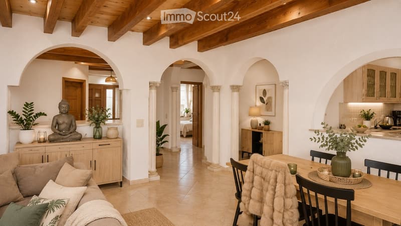 A spacious living area with a sofa, dining table, and kitchen area. Features include wooden beams, arched doorways, and decorative items such as vases, plants, and a Buddha statue.