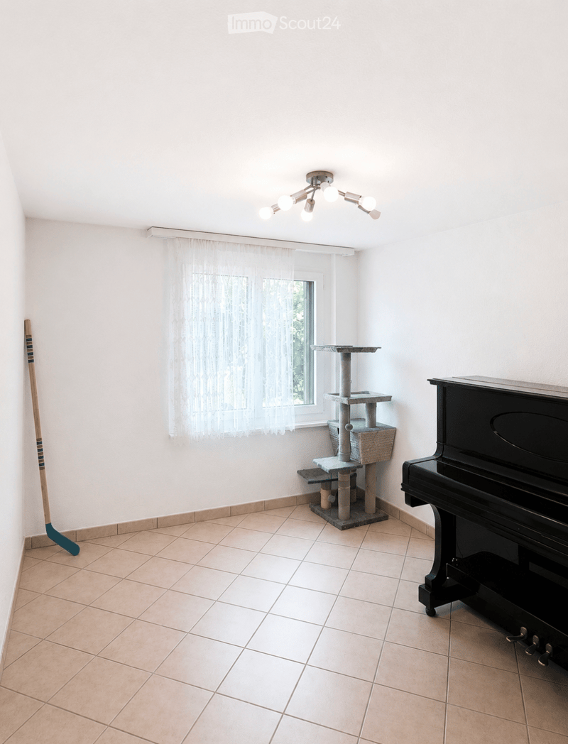 Bright room with tiled floor, white walls, large window with sheer curtains, cat tree, grand piano, and multi-bulb ceiling light fixture.