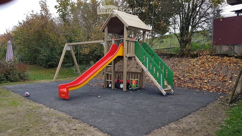 Play area with a slide, swing, and climbing frame.