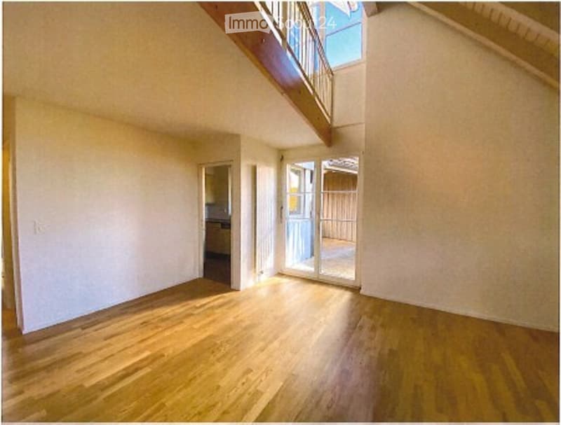 Empty room with wooden flooring, white walls, and large windows letting in natural light. No furniture or equipment present.