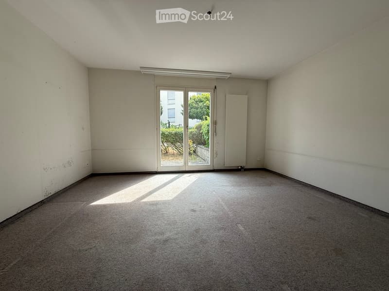 Empty room with carpeted floor, white walls, and large sliding glass doors leading to an outdoor area.
