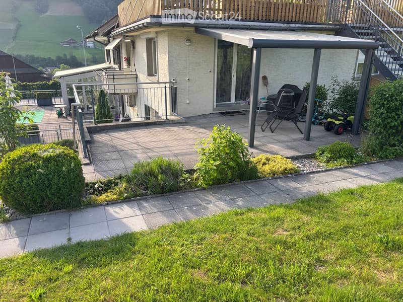 Garden and patio area with a covered patio, outdoor furniture, and a view of a green landscape.