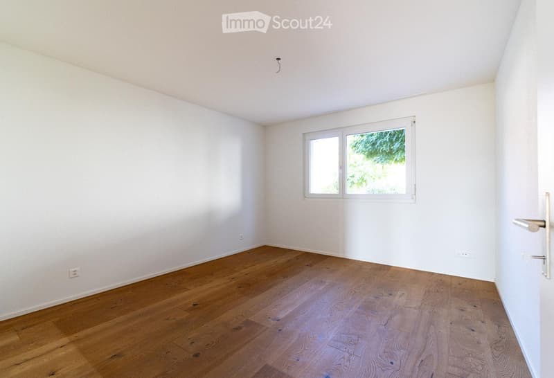 Empty room with wooden flooring, white walls, and a single window with white frame. No furniture or equipment present.