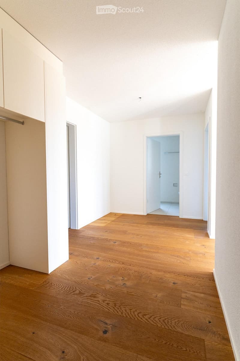 Completely empty room with light wooden flooring and white walls. No furniture or equipment visible.