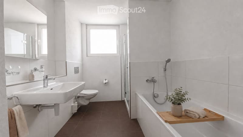 Modern bathroom with white tiles, a sink, mirror, toilet, bathtub, and a small plant on the edge of the tub.