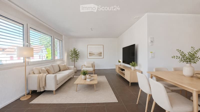 Modern living room with large windows, white walls, and a mix of seating and dining areas. Features a white sofa, coffee table, armchair, dining table with chairs, floor lamp, TV stand, and several decorative plants.