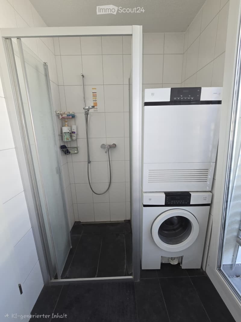 Modern bathroom with a shower area and a stacked washing machine and dryer unit. The shower has a glass door and a built-in shelf for toiletries.