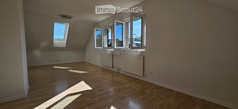 Unfurnished Room. Empty room with wooden floors, white walls, and three windows. Two white radiators are mounted on the wall.