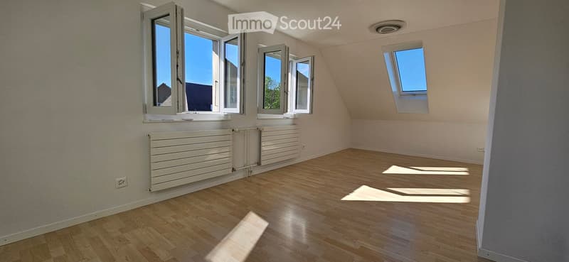 Unfurnished Room. Empty room with wooden floors, white walls, and three windows. Two large windows and one small window. Two white radiators on the wall.