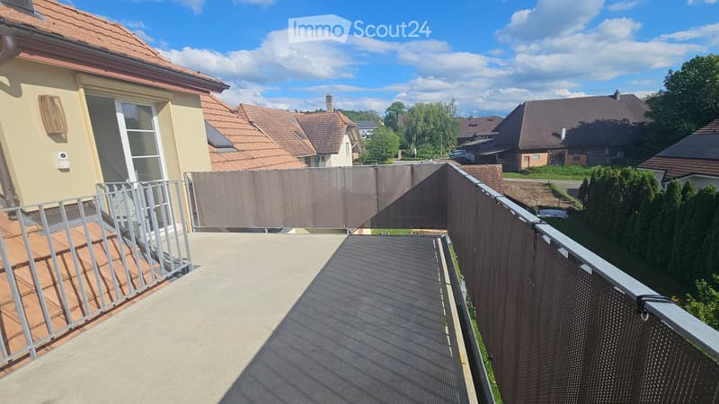 Balcony / Terrace. Balcony with metal railing, covered section, and view of neighboring houses and greenery.