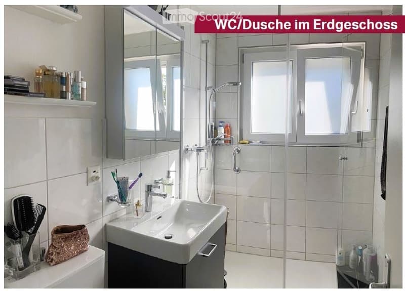 Modern bathroom with a white tiled shower area, a sink with a mirror cabinet, and various toiletries neatly arranged on shelves and the sink counter.