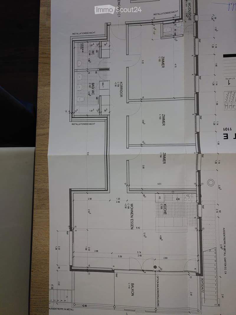 Floor plan showing a residential layout with rooms labeled: Wohnzimmer (living room), Küche (kitchen), Schlafzimmer (bedroom), Badezimmer (bathroom), and Balkon (balcony).