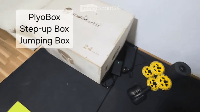 A room with a step-up box labeled "PlyoBox Step-up Box Jumping Box" and a pair of yellow skates placed on the floor.