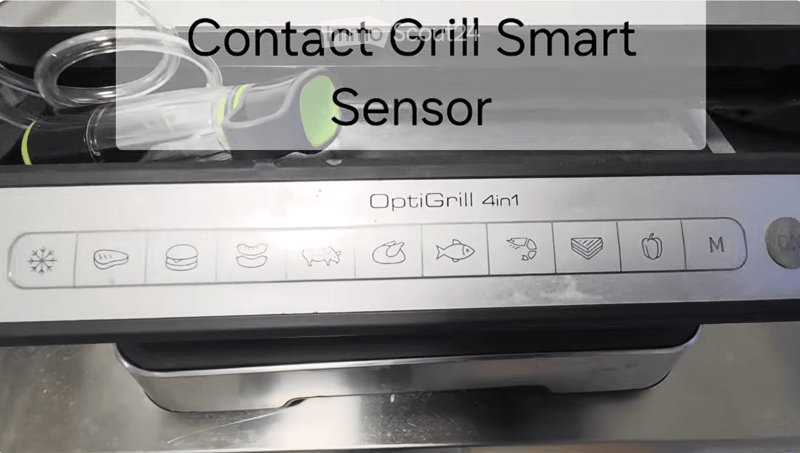 A modern kitchen grill with a contact grill smart sensor attached, featuring various food icons on the control panel.