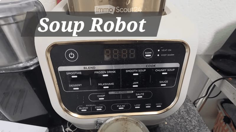 A modern soup robot with a digital control panel featuring multiple cooking and blending options, including settings for smoothies, frozen drinks, soups, desserts, milkshakes, jams, sauces, and more. The control panel includes buttons for blend, cook, cho
