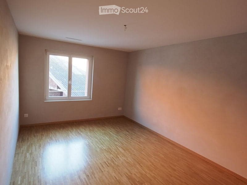 Empty room with wooden flooring and a single window, no furniture or equipment present.