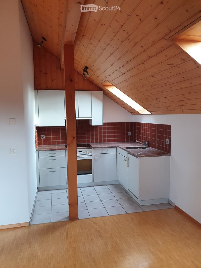 Compact kitchen with white cabinets, a sink, an oven, and a countertop, featuring a wooden ceiling and tiled backsplash.