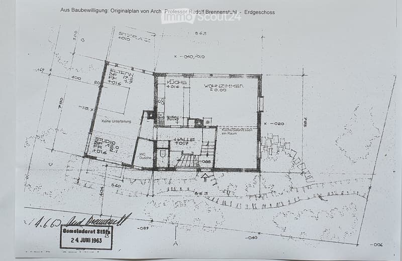 Architectural floor plan of the ground floor, showing rooms labeled in German: kitchen, living room, studio, hallway, and bathroom.