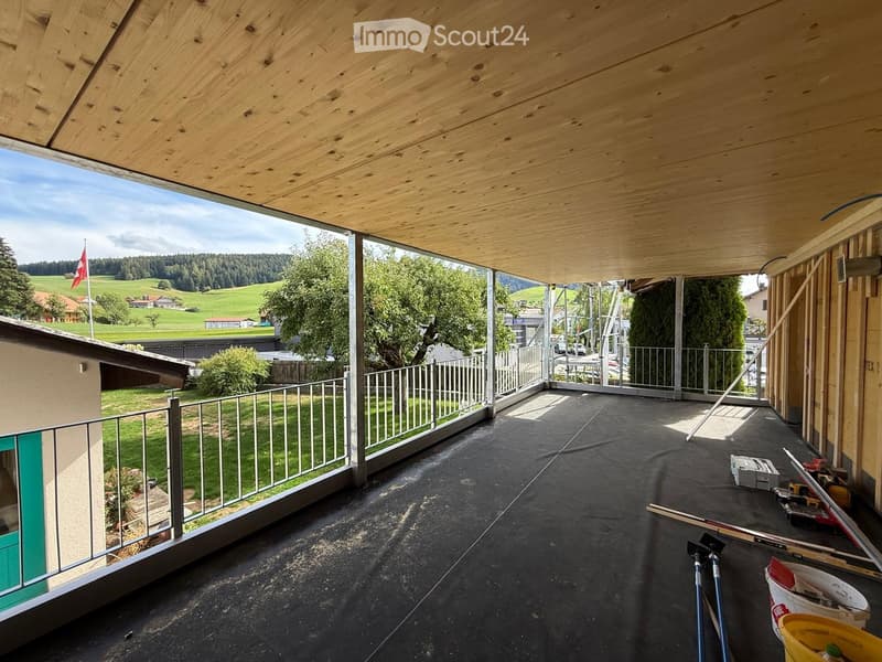 Balcony with wooden ceiling, metal railing, and scenic countryside view.