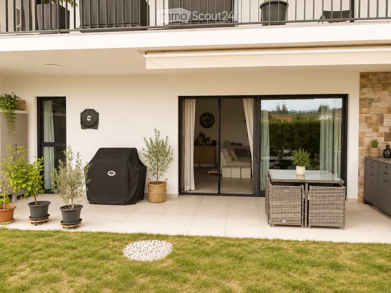A modern outdoor patio with a tiled floor, a glass sliding door leading to a living room, a dining table with two chairs, several potted plants, and a covered grill.