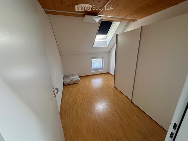 Empty room with wooden flooring, white walls, and a skylight window. No furniture or equipment present.