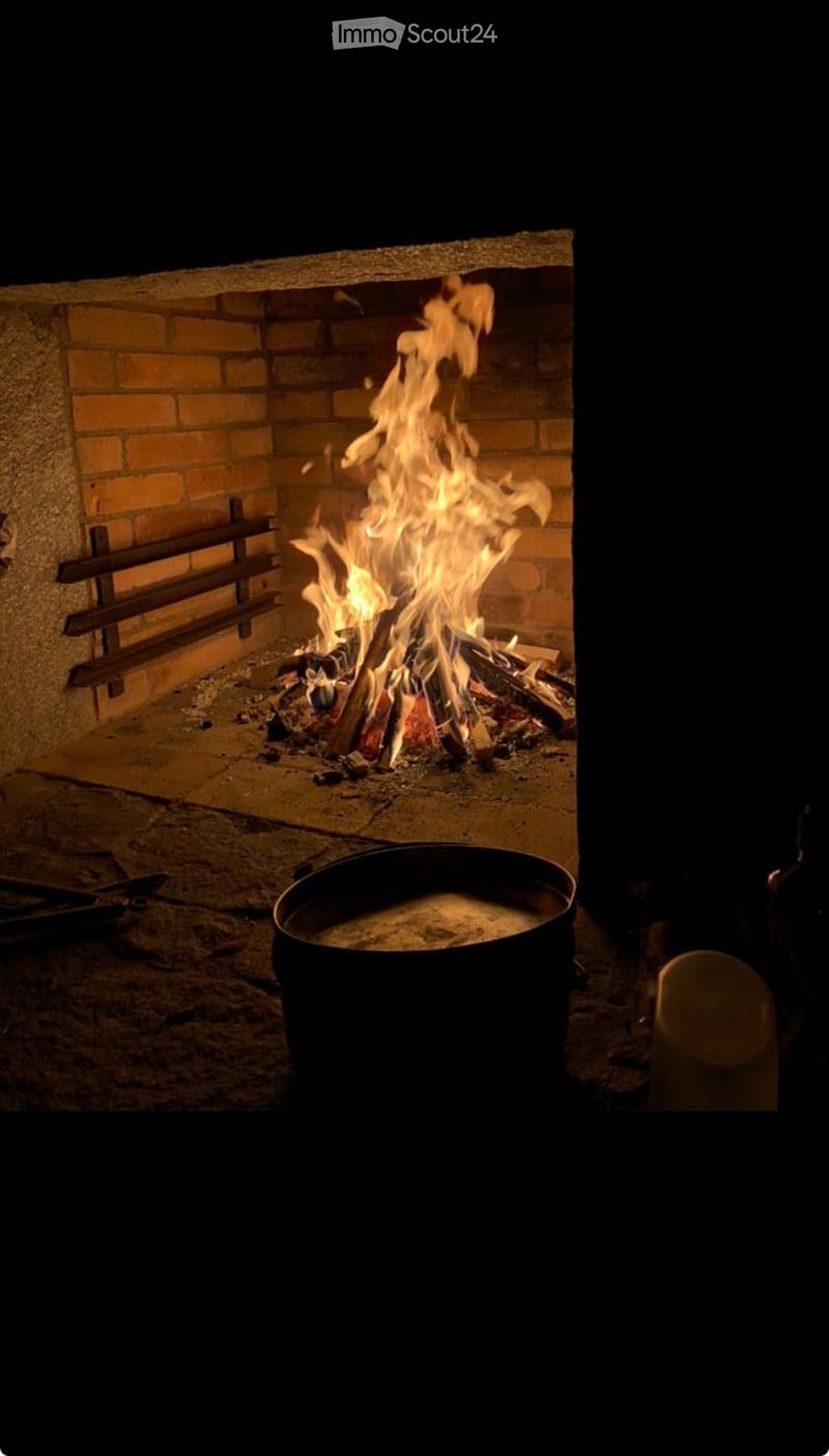brick wall, fireplace, burning logs, metal grate, pot