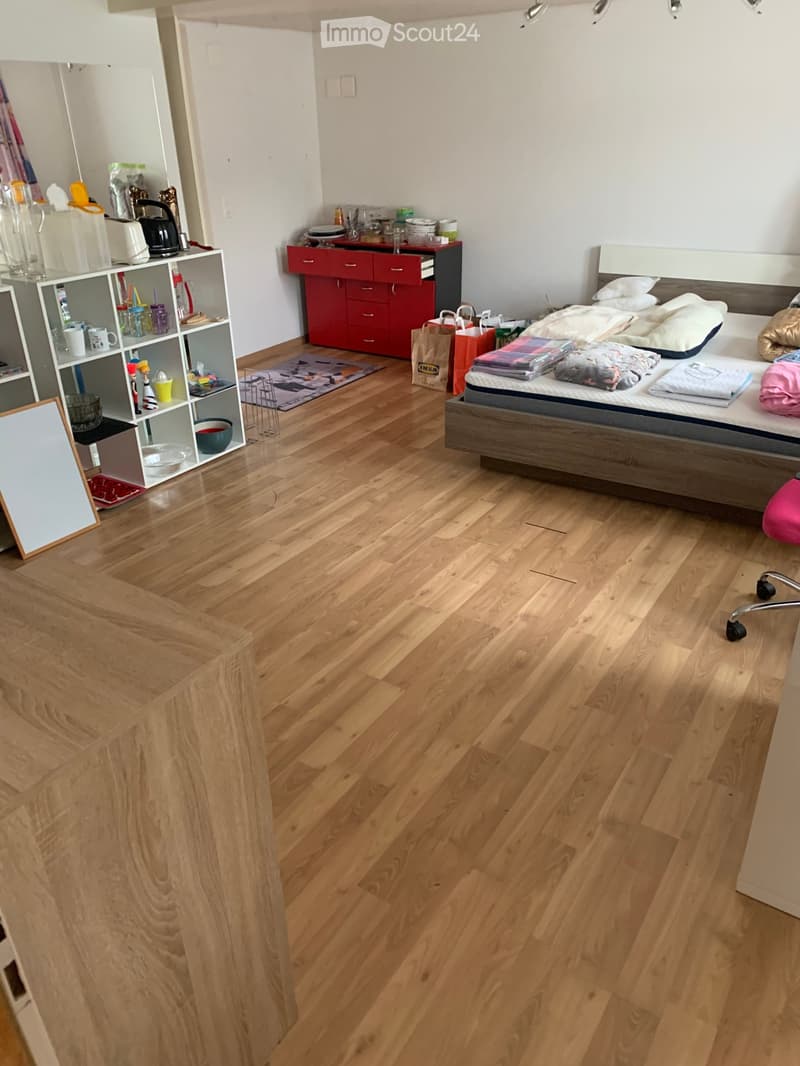 Single bed, bedroom, wooden floor, shelves, table, bed, IKEA bag, cabinet, mat, roll of paper towels, bowl, kettle, cups, glasses