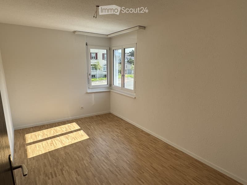 empty room with hardwood floor, white walls, two windows