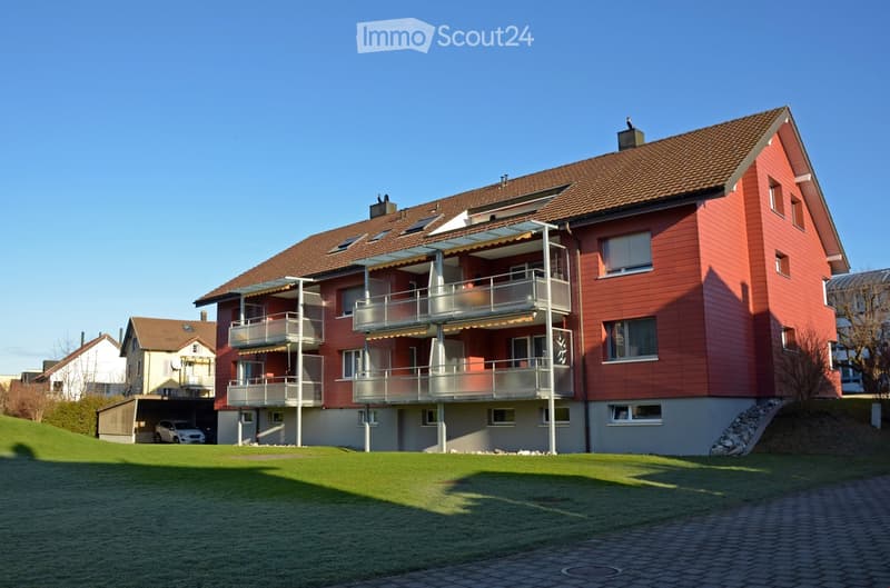 Large red residential building with balconies, two floors, with underground garage