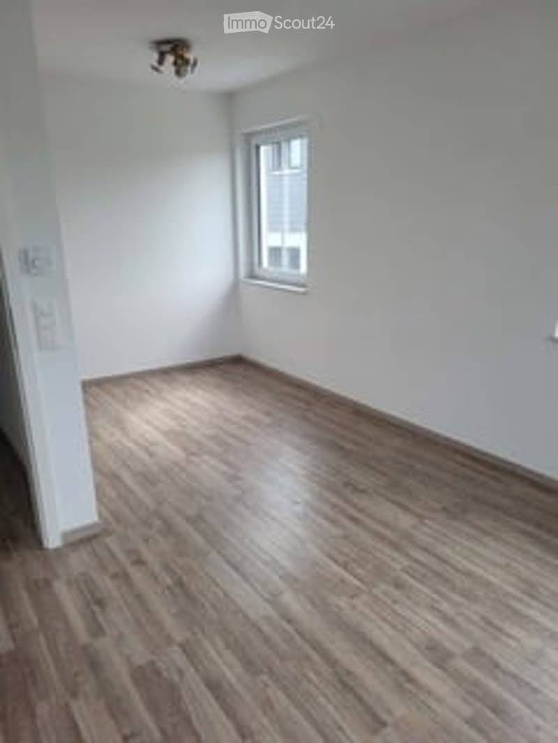Completely empty room with wooden flooring and white walls. No furniture or equipment.