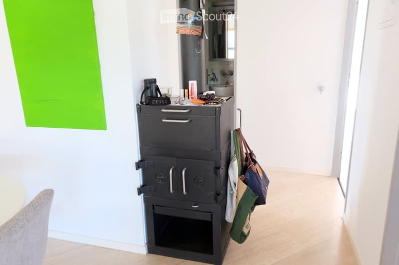 A compact hallway with a built-in oven unit, a small sink area, and a handbag hanging on the wall.