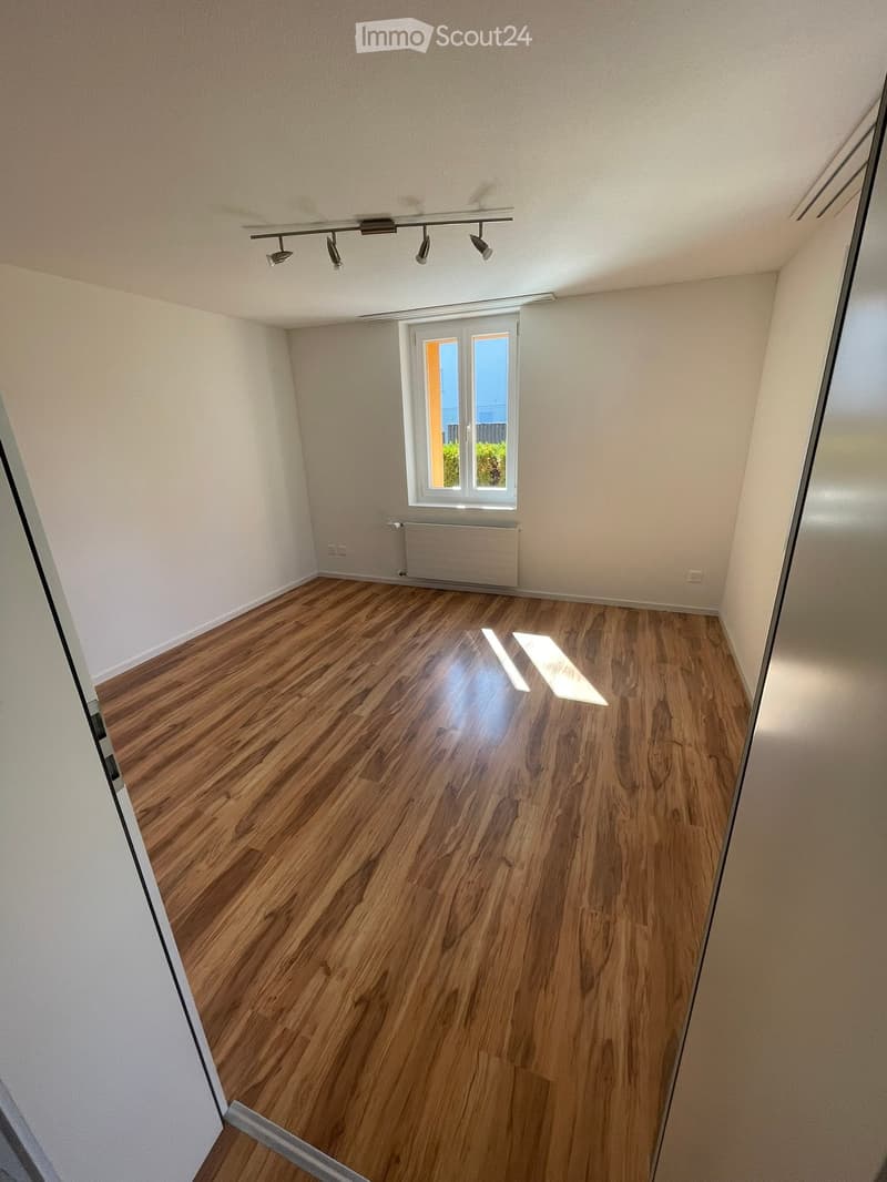 Empty room with wooden flooring, white walls, and a window with blinds. No furniture or equipment is present.