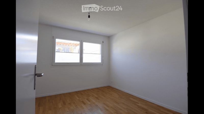 Empty room with wooden flooring, white walls, and a window with white frames. No furniture or equipment is present.