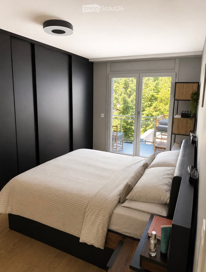 Modern bedroom with a large bed, nightstand, and a sliding glass door leading to a balcony with outdoor seating.