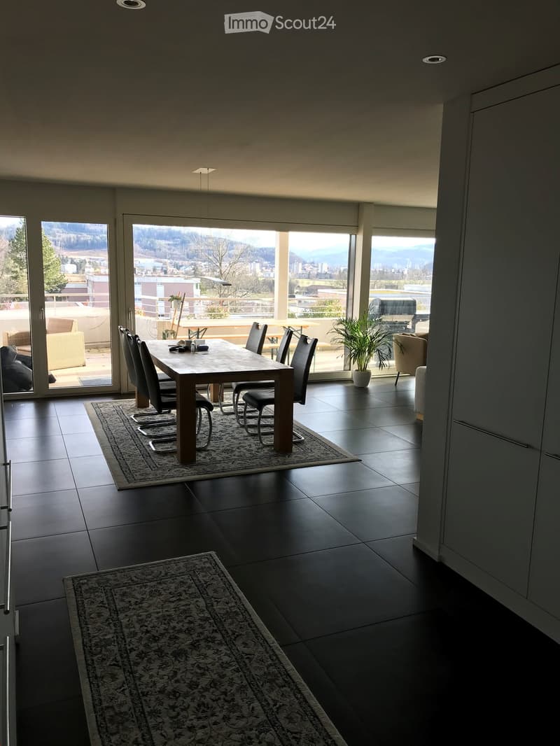 Dining table, 6 chairs, large glass windows, sliding doors, balcony, rug, black floor tiles