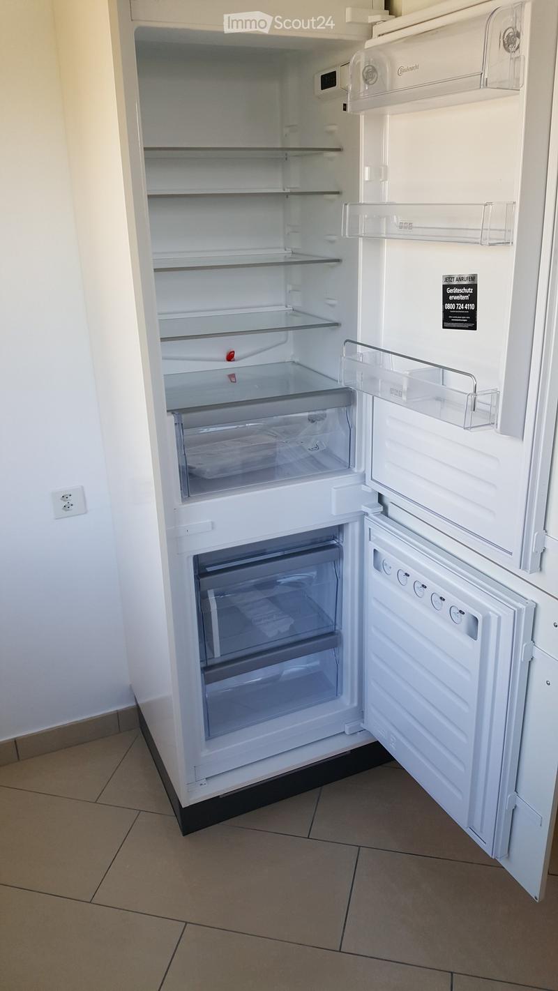 A modern white refrigerator with multiple compartments and shelves, fully open, showing an empty interior.
