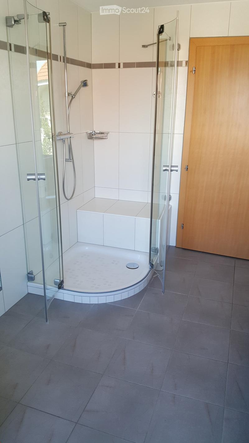 Modern bathroom with a walk-in shower, glass enclosure, and tiled walls and floor.
