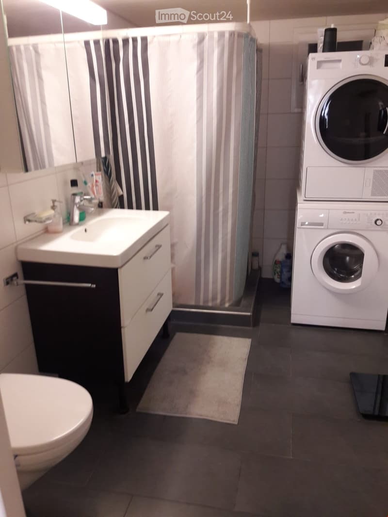 a bathroom with a white toilet, sink, and shower with a white curtain
