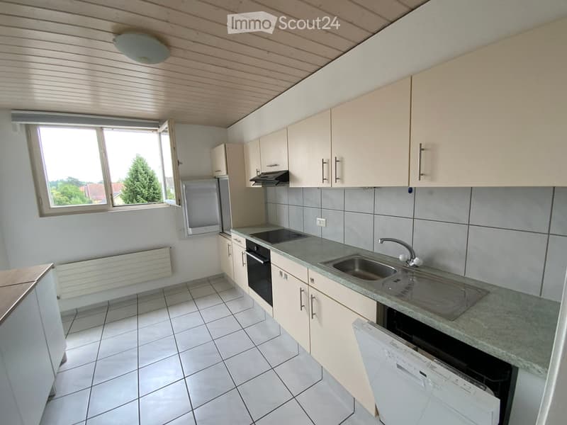 Modern kitchen with white cabinets, tiled floor, granite countertop, sink, oven, refrigerator, and dishwasher.