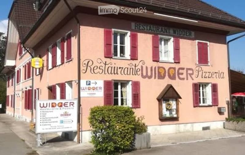 Pink building with white trim, labeled "Restaurant Widder Pizzeria" with multiple windows and shutters.
