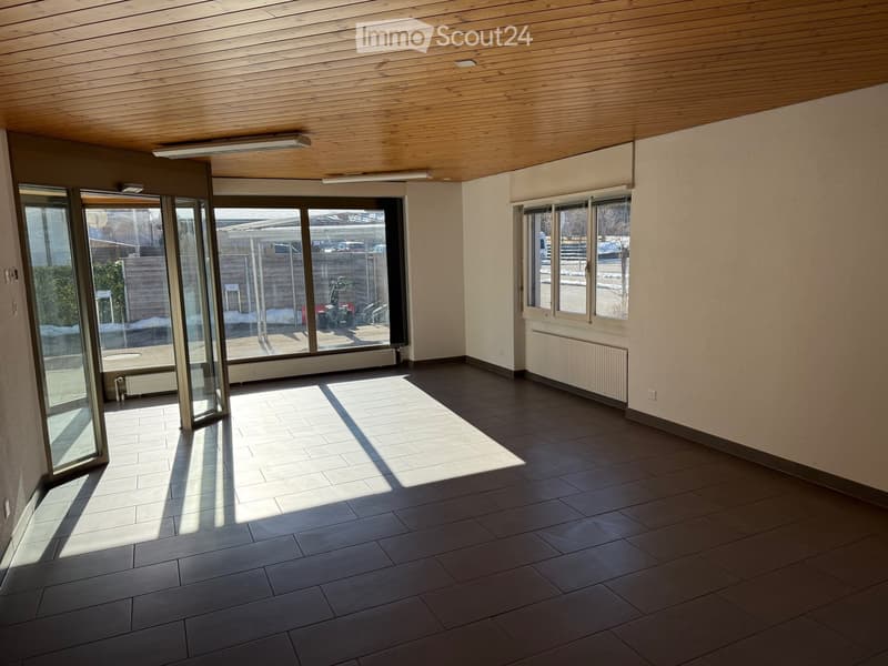 Empty room, tiled floor, large glass doors, glass windows, wooden ceiling, radiators, light fixtures