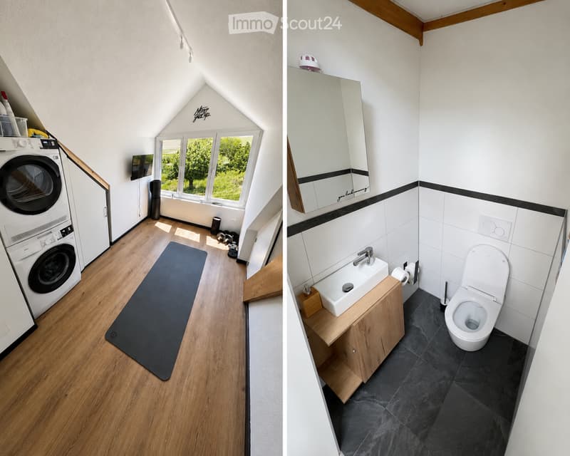 Modern bathroom with white tiles, dark grey floor, wooden vanity, and a large mirror. Includes a toilet, sink, and a cabinet.