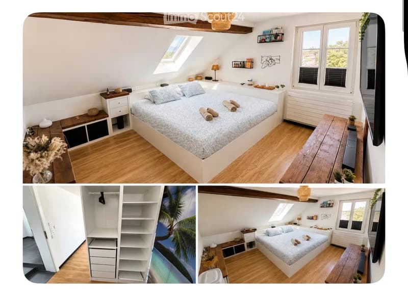 Cozy attic bedroom with wooden floors, slanted ceilings, and large windows. Features a double bed with patterned bedding, nightstand, small table, and built-in shelving.
