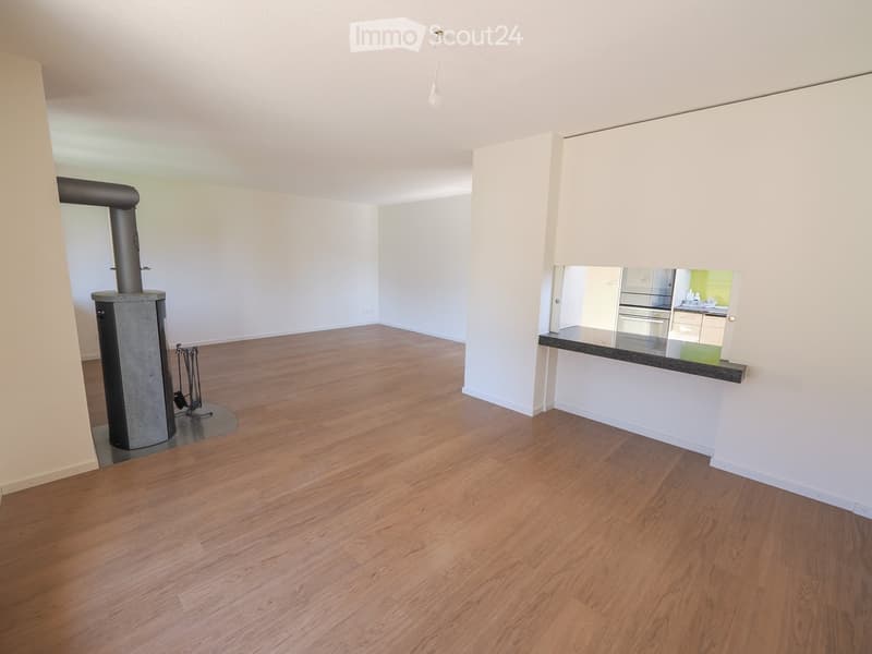 Empty room with wooden flooring, white walls, and a visible fireplace in the background. No furniture or equipment present.