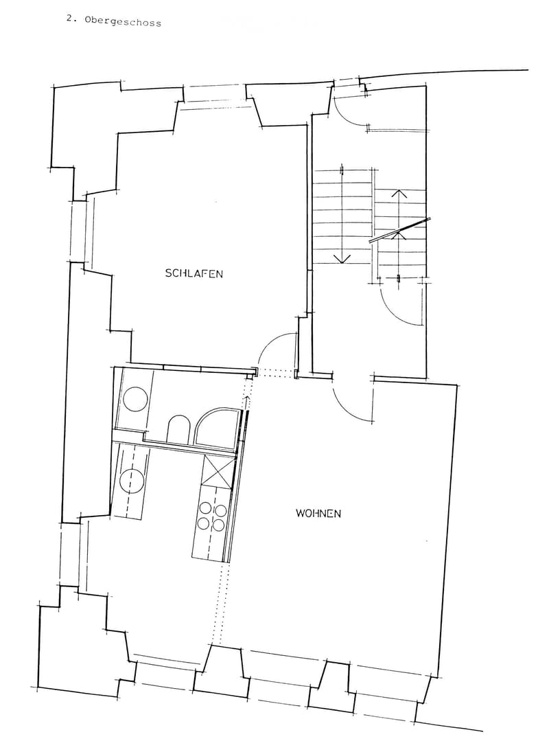 Floor plan of the second floor showing a bedroom and a living area with a staircase leading to another level.