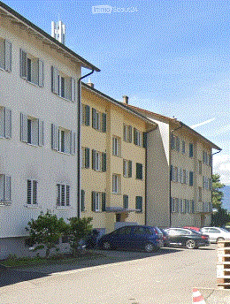 multistory apartment buildings, yellow exterior, white windows, cars parked in front