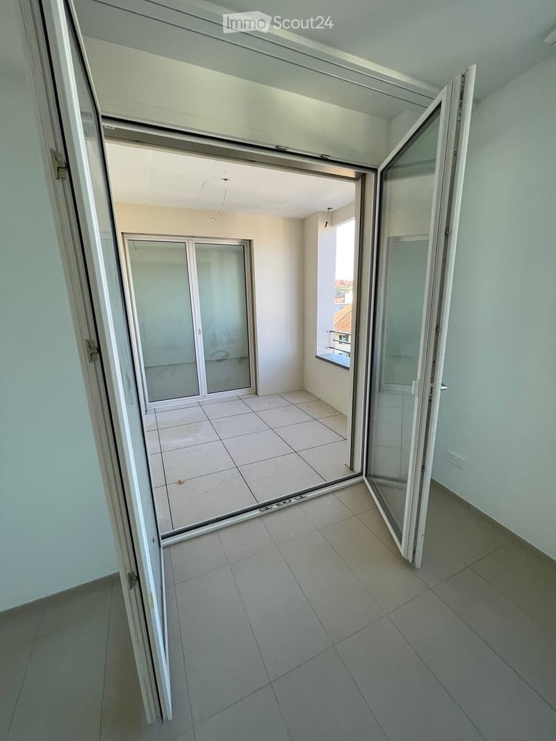 open balcony doors, white tile floor, white walls, glass sliding doors leading to balcony